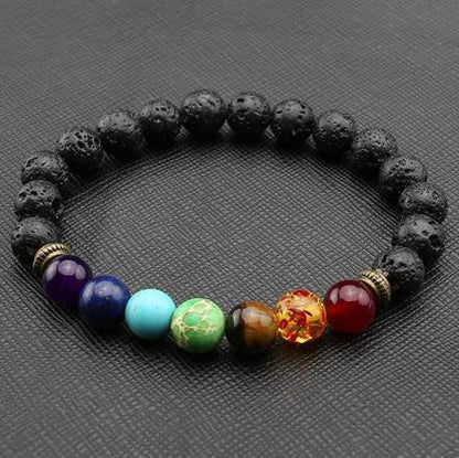 A beaded bracelet made with black lava stone and multicolored beads representing the seven chakras.