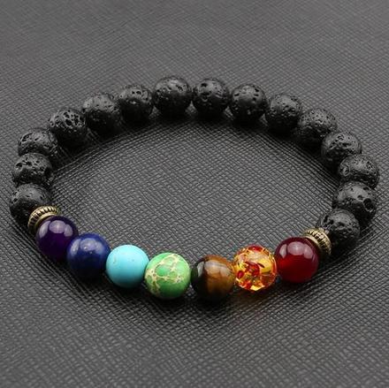 A beaded bracelet made with black lava stone and multicolored beads representing the seven chakras.